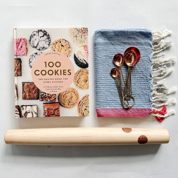 100 Cookies cookbook paired with a beautiful rolling pin from Untitled Co, copper meansuring spoons and a pretty kitchen towel