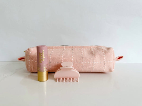 Small Anchal toiletry bag in a pale pink paired with a hair claw and lip tint in the same shades of pink. 