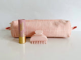 Small Anchal toiletry bag in a pale pink paired with a hair claw and lip tint in the same shades of pink. 