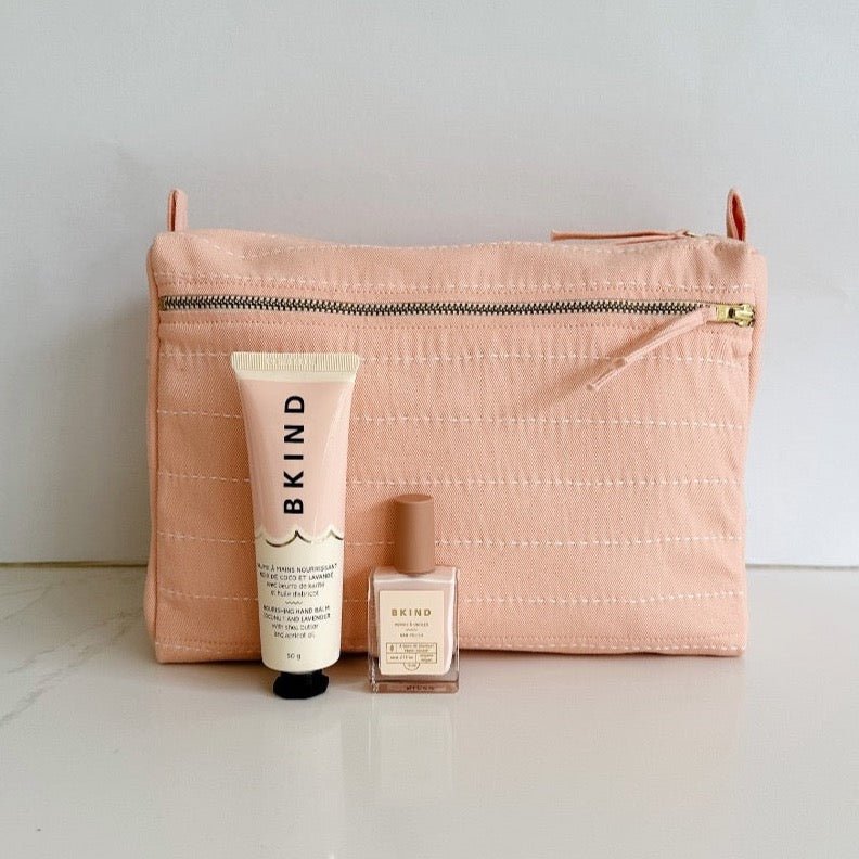 Pale pink toiletry bag paired with Bkind Nail polish and hand lotion for a sweet gift.