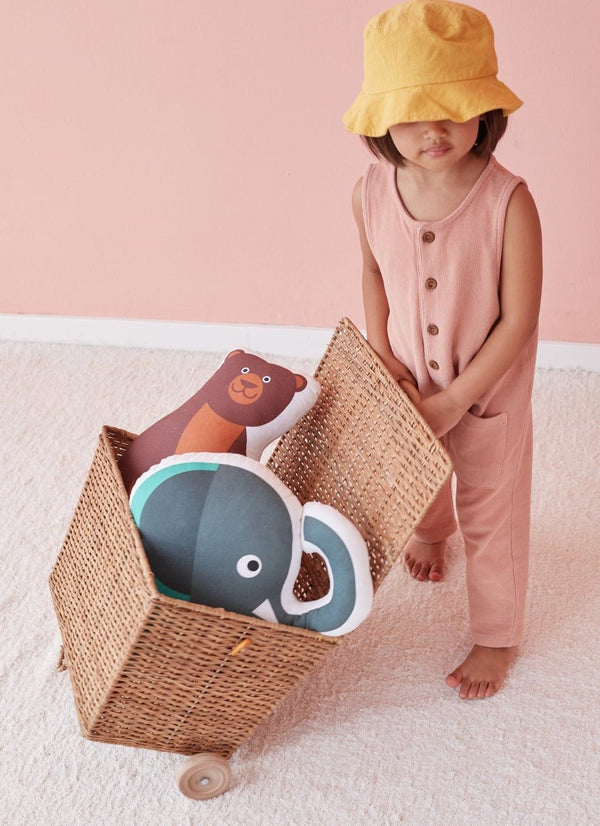 Young child playing with bear and elephant cushions