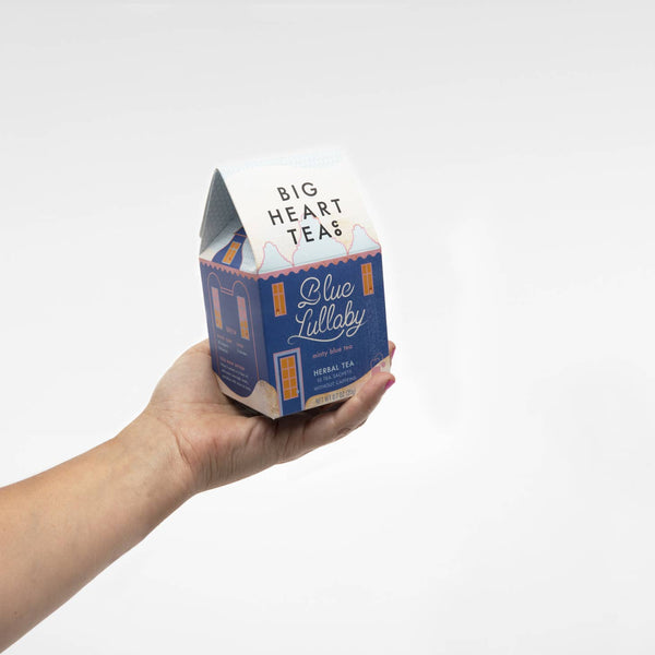 Hand holding a box of Big Heart Tea Co Blue Lullaby tea.