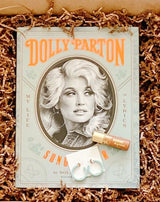 Dolly Parton book paired with lip tint from Poppy & Pout and Sol Earrings from Nat and Noor.