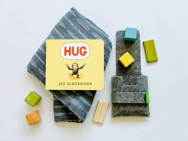 Muslin swaddle blanket paired with Hug book and Tegu blocks. A sweet kid's gift combination.